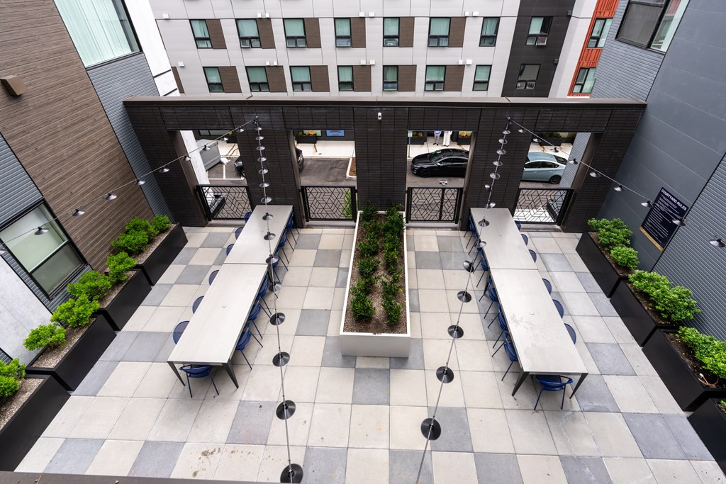 A courtyard with benches and a planter in the middle.