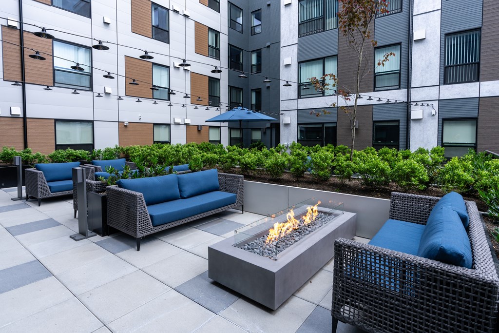 A patio with a fire pit and seating area.