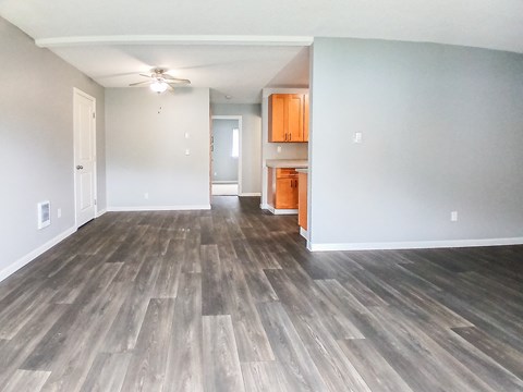 A room with wooden flooring and a ceiling fan.