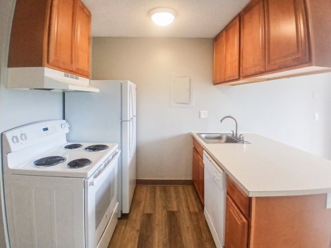 A white stove and oven in a kitchen with wooden cabinets.