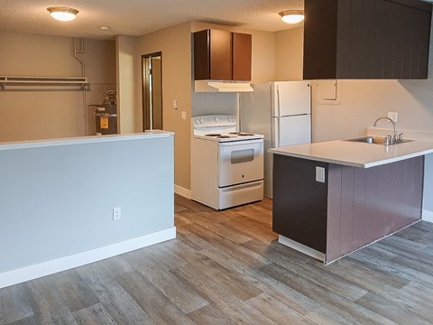 A kitchen with a white fridge and a white stove top oven.