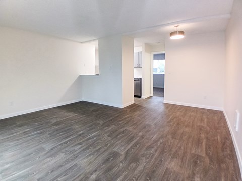 A room with wooden flooring and white walls.