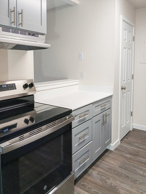 A modern kitchen with a stove top oven and a counter top.