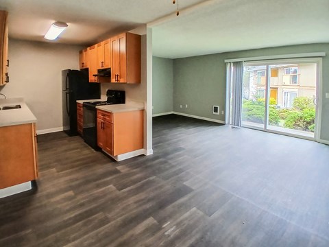 A kitchen with wooden cabinets and a black refrigerator.