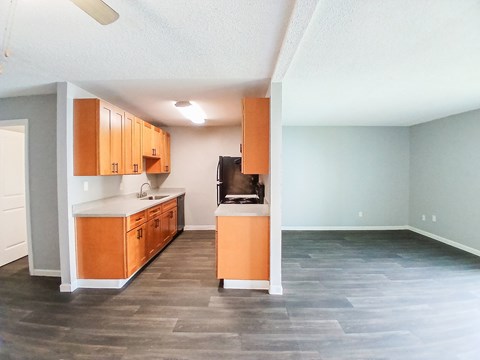 A kitchen with wooden cabinets and a black fridge.
