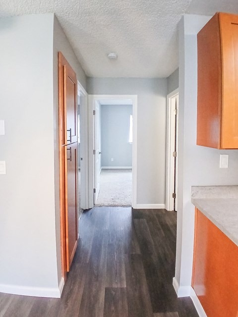 A hallway with wood floors and white walls.