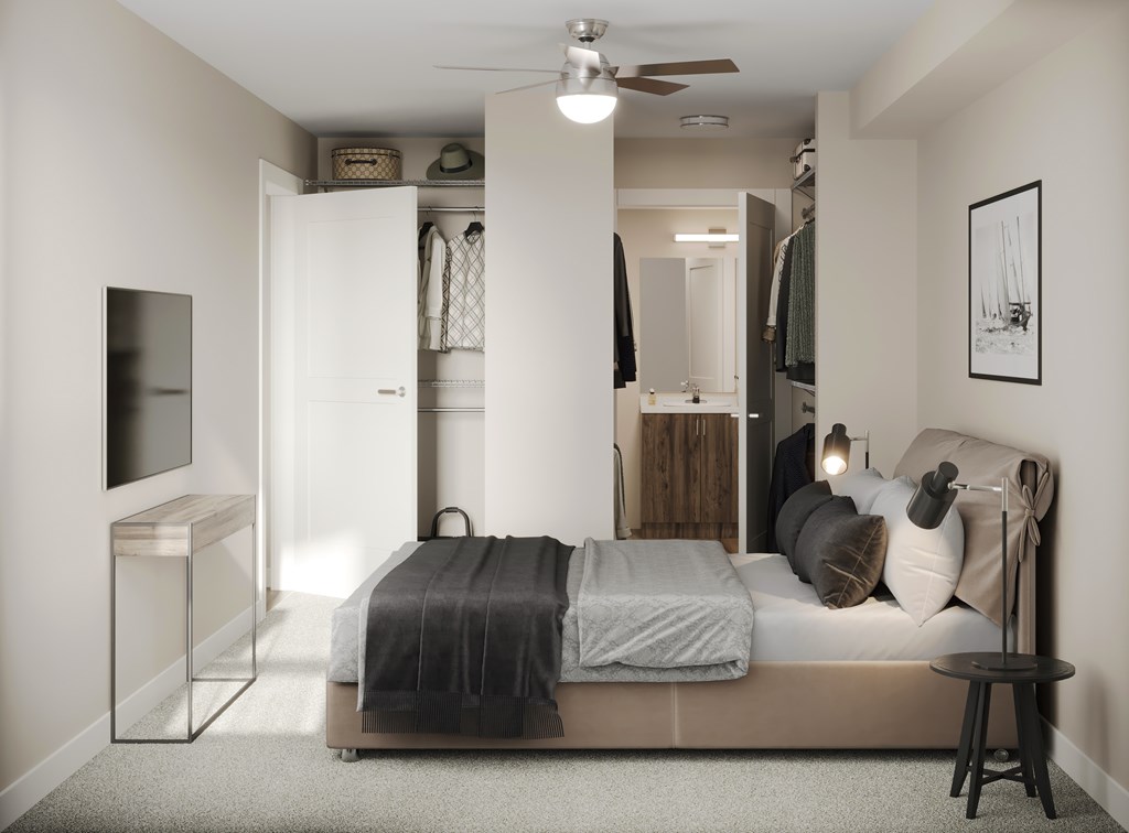 A bedroom with a bed, a TV, and a ceiling fan.