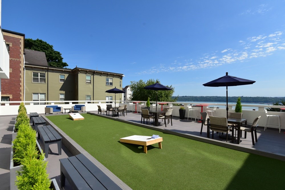 A patio area with a table and chairs overlooking a body of water.