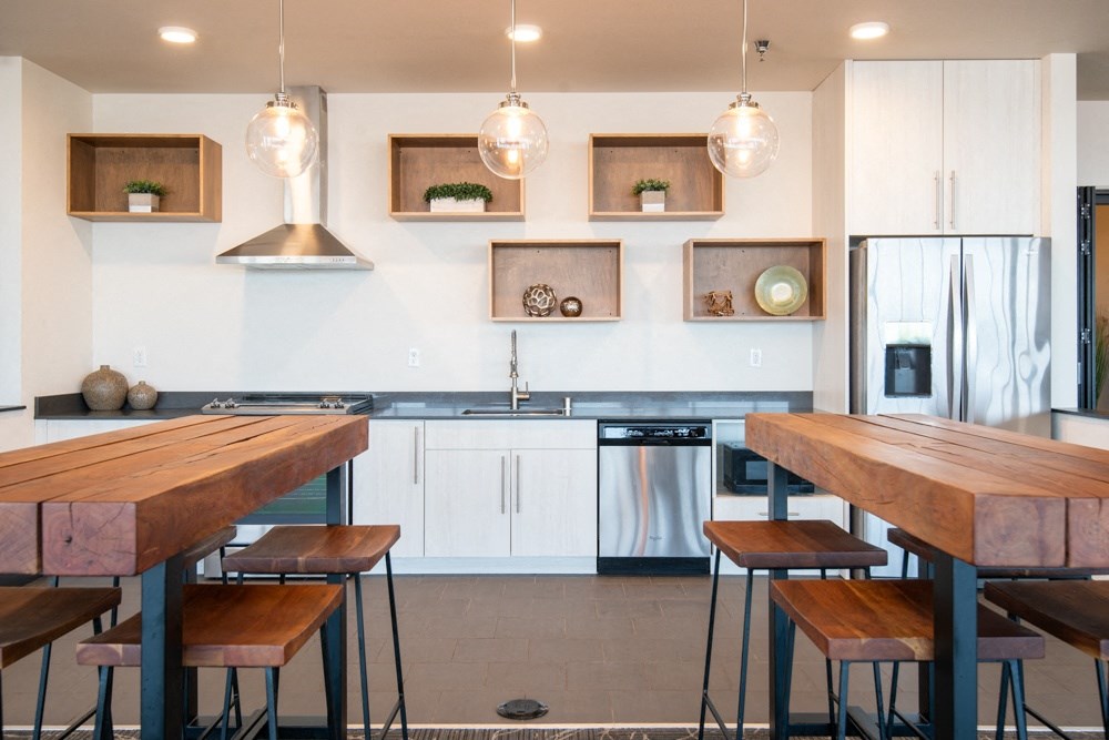 A modern kitchen with a wooden table and stools.