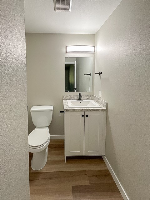 A white toilet sits next to a sink in a small bathroom.