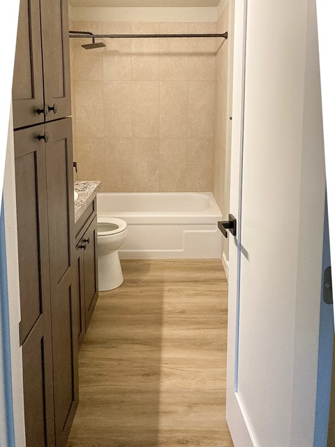 A small bathroom with a toilet, sink and bathtub.