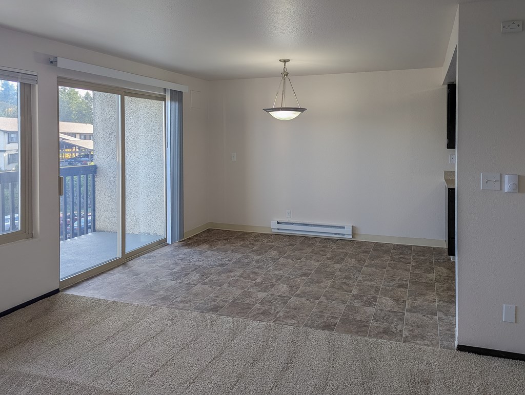 A room with a carpeted floor and a hanging light fixture.
