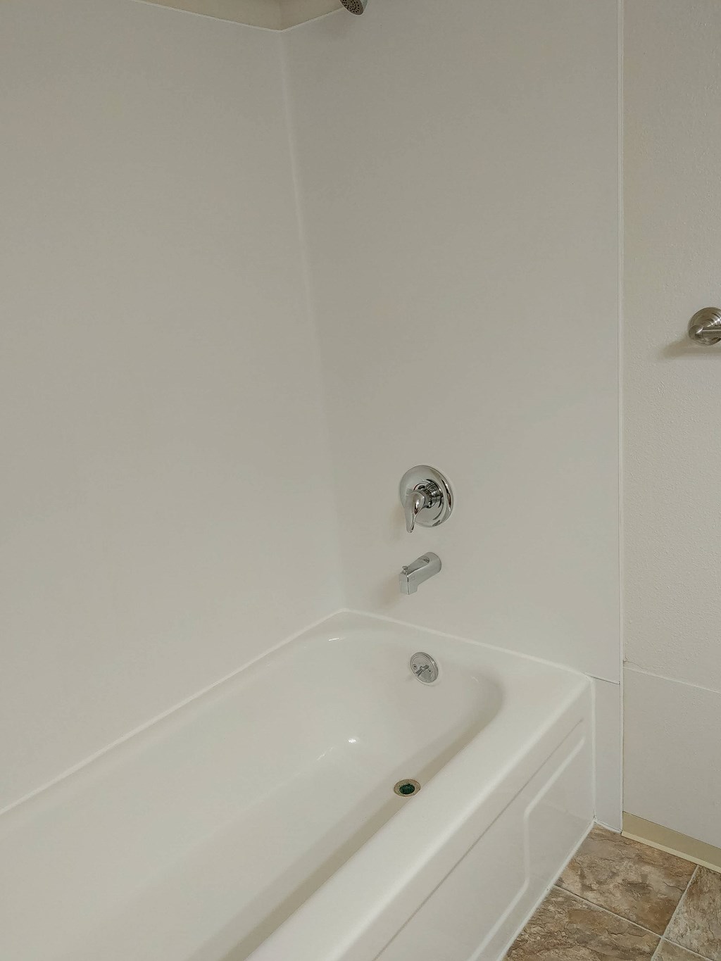 A white bathtub with a shower head and faucet.