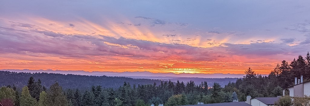 A beautiful sunset with vibrant colors and rays of light shining through the clouds.