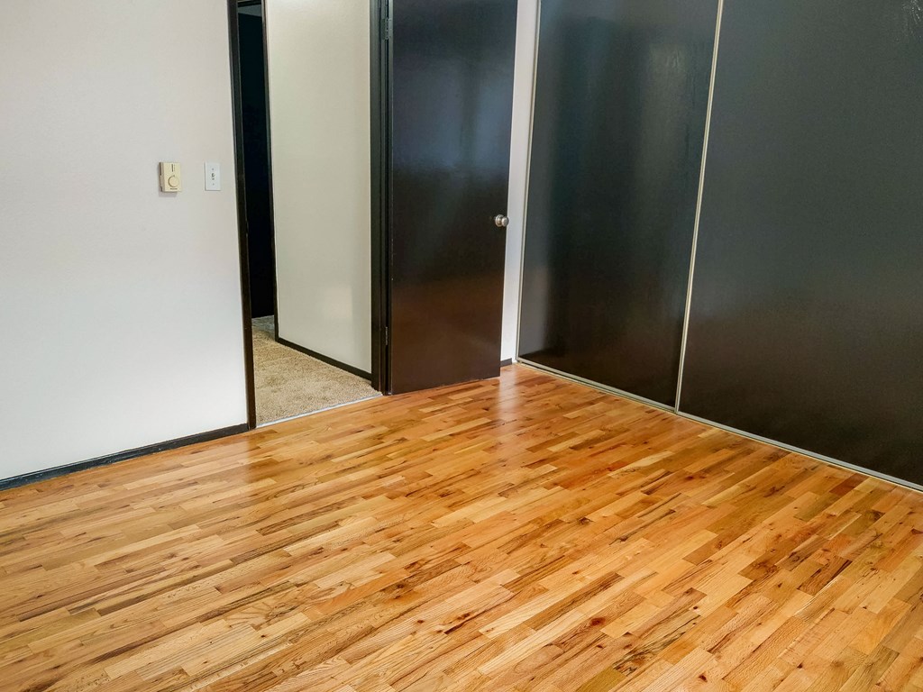 A room with a wooden floor and a glass door.