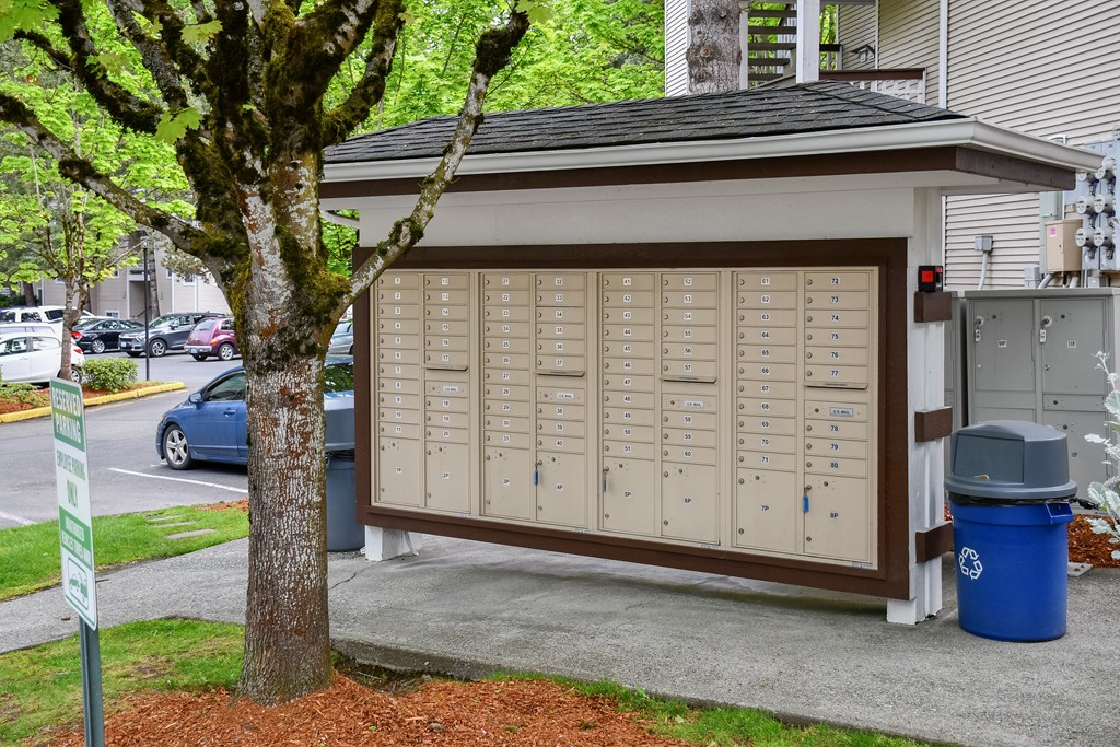 A brown and white garage door with a tree in front of it.
