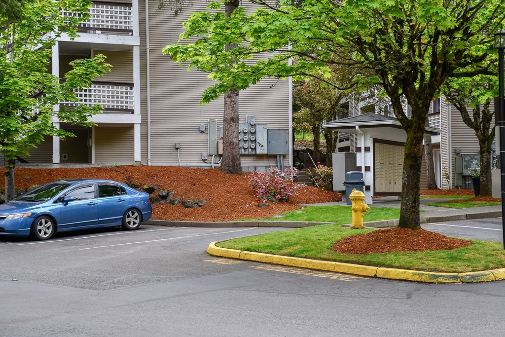 A blue car is parked in front of a building.