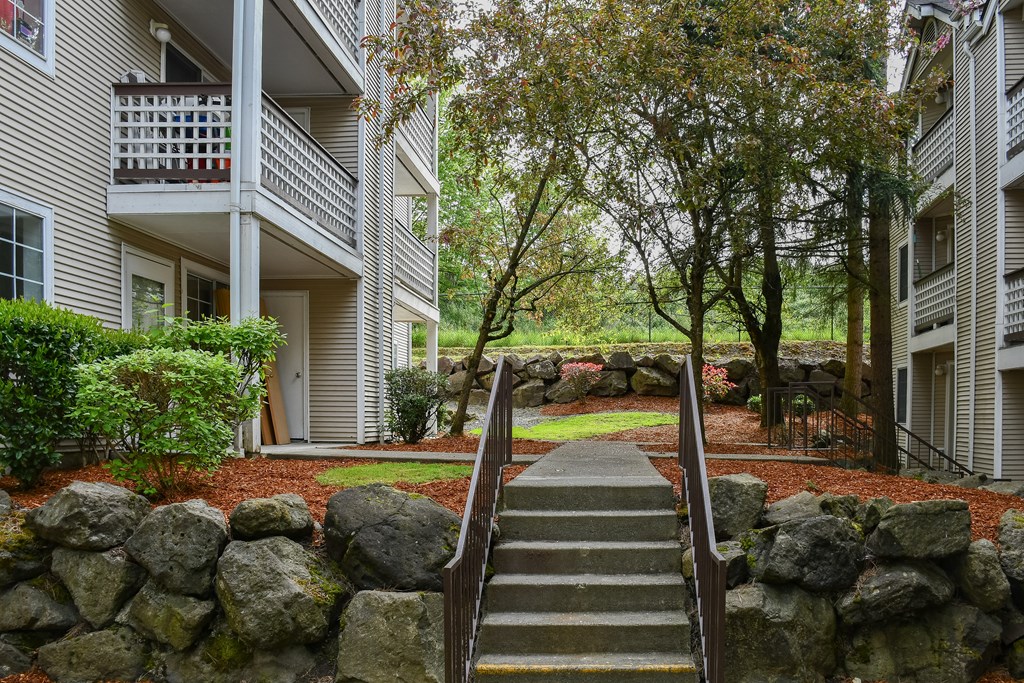 A stone staircase leads up to a balcony in a residential building.