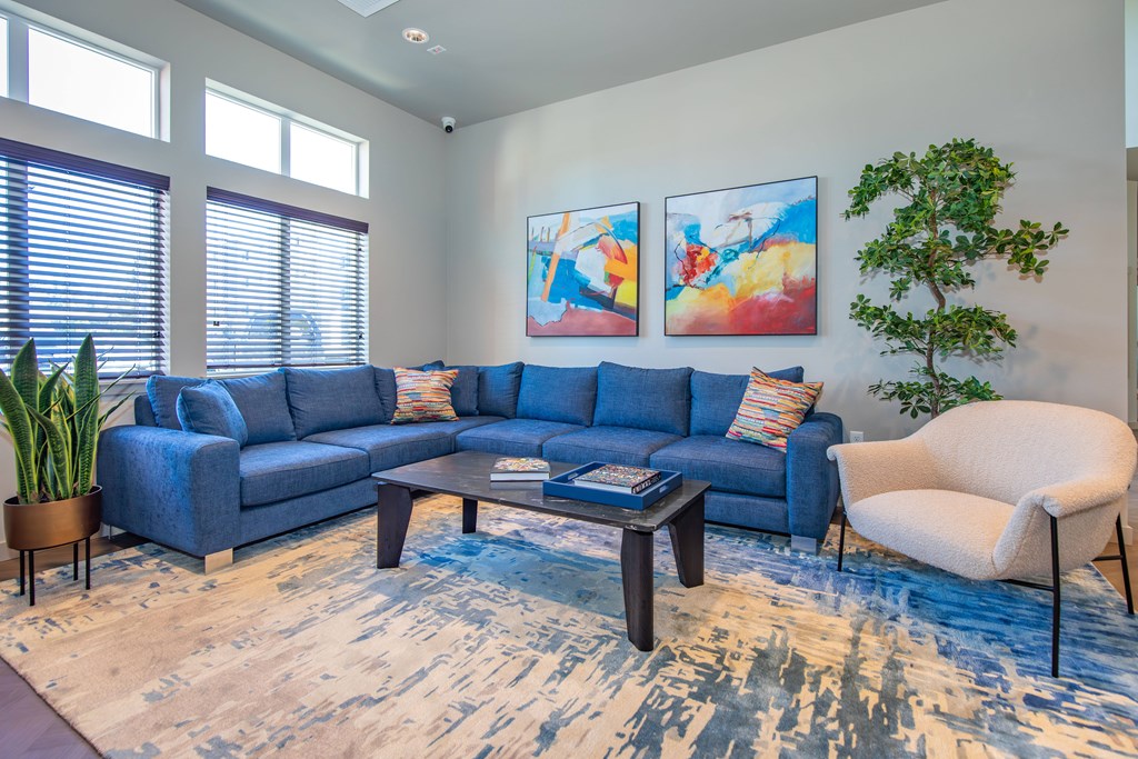 A living room with a blue couch and a white chair.