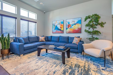 A living room with a blue couch and a white chair.