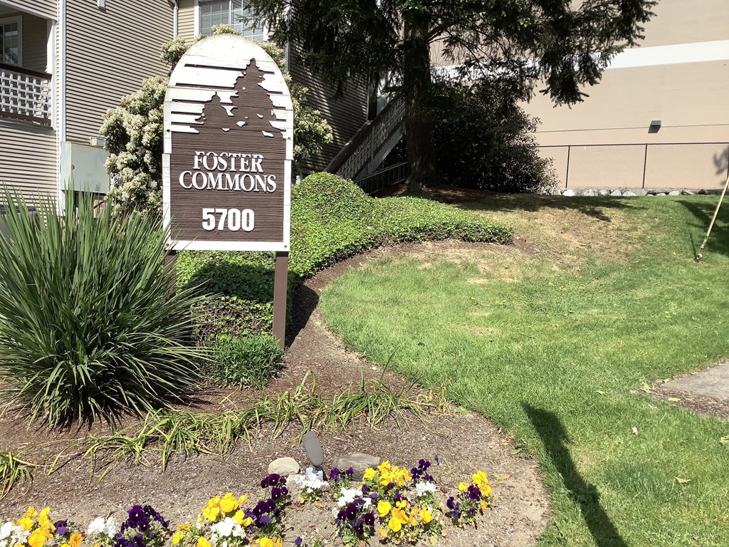 A sign for Foster Commons 5700 stands in a flower bed.