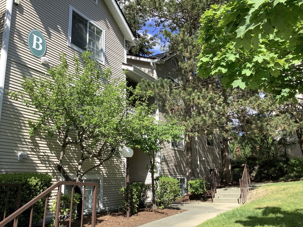 A building with a B on it is surrounded by trees.
