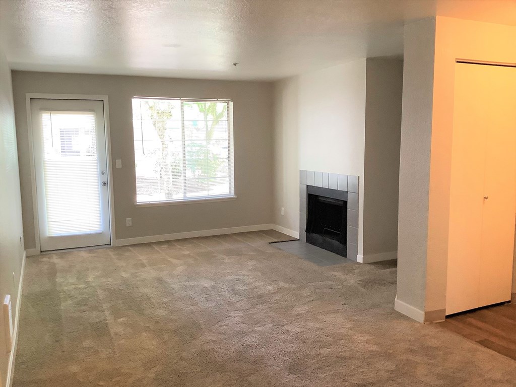 A living room with a fireplace and a carpeted floor.