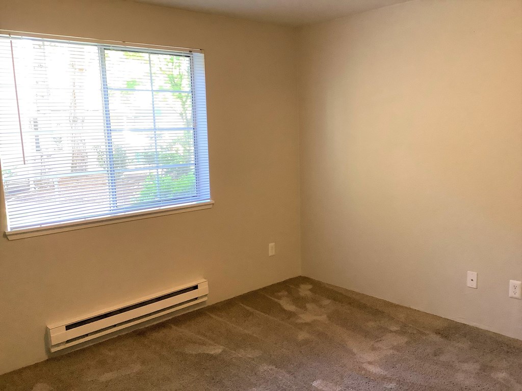 A room with a window and a wall-mounted air conditioner.