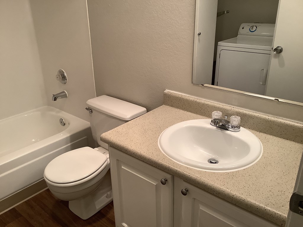 A white toilet sits next to a sink in a bathroom.