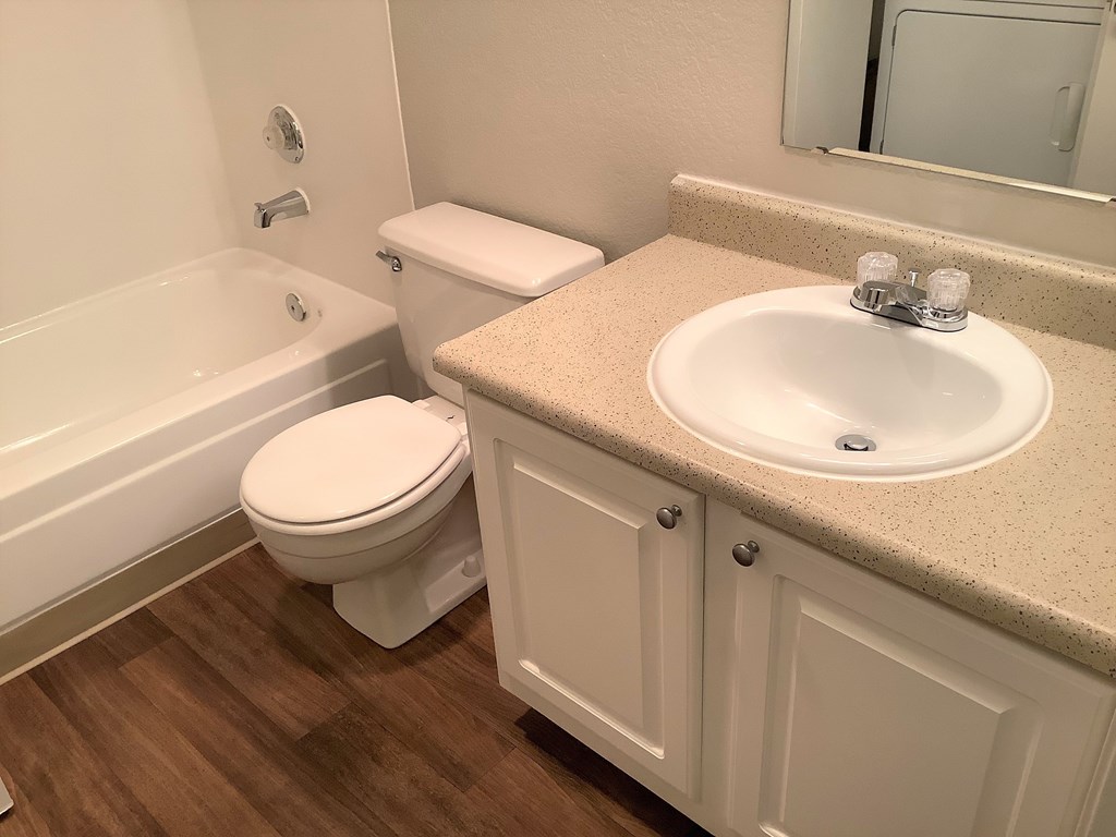 A white toilet sits next to a sink in a bathroom.
