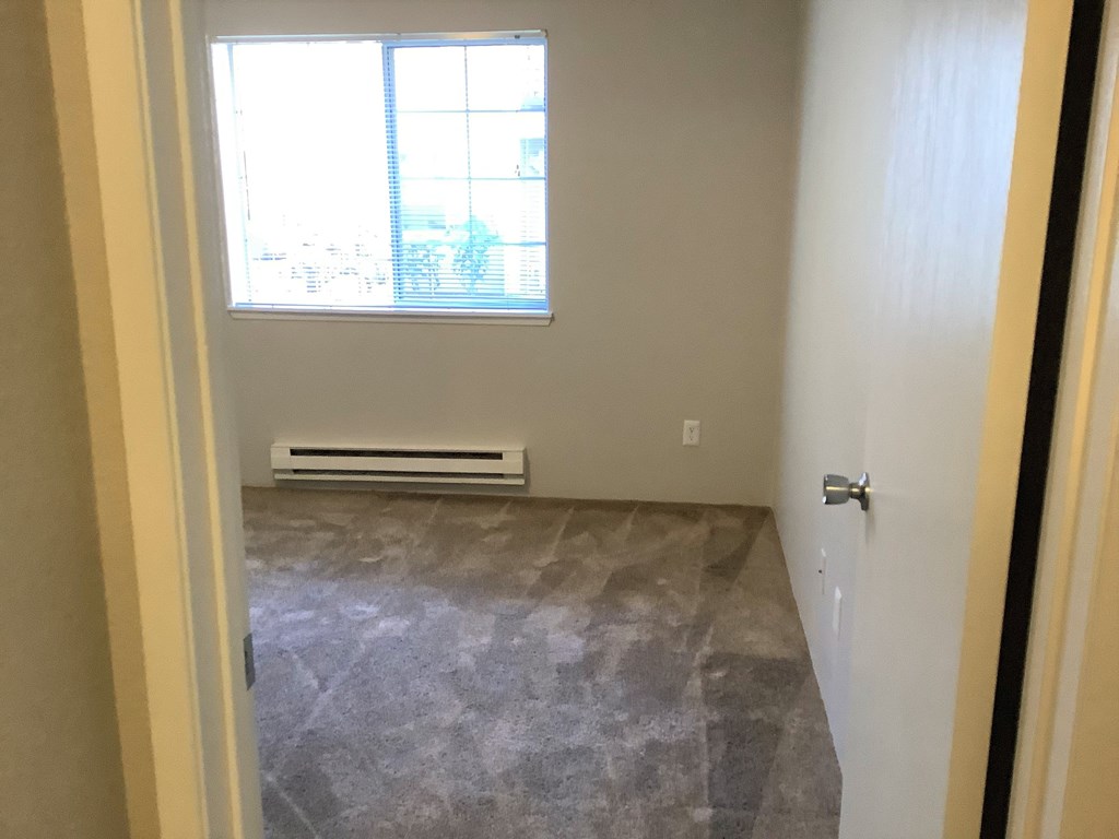 A room with a window and a tiled floor.