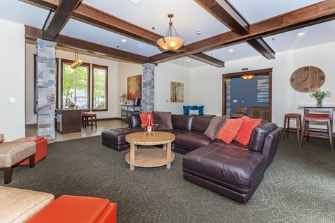 A living room with a large couch and a stone pillar.