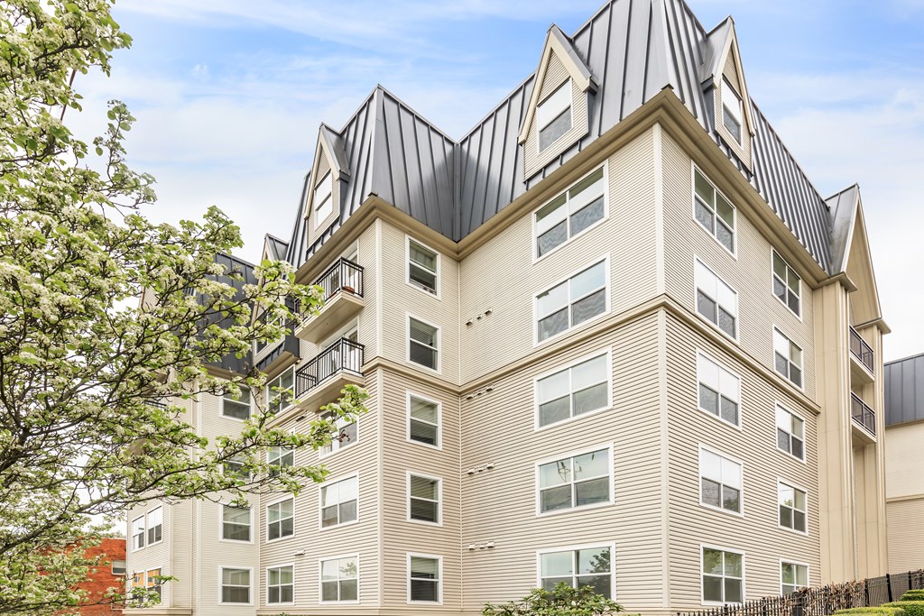 A tall building with a unique design and a black roof.