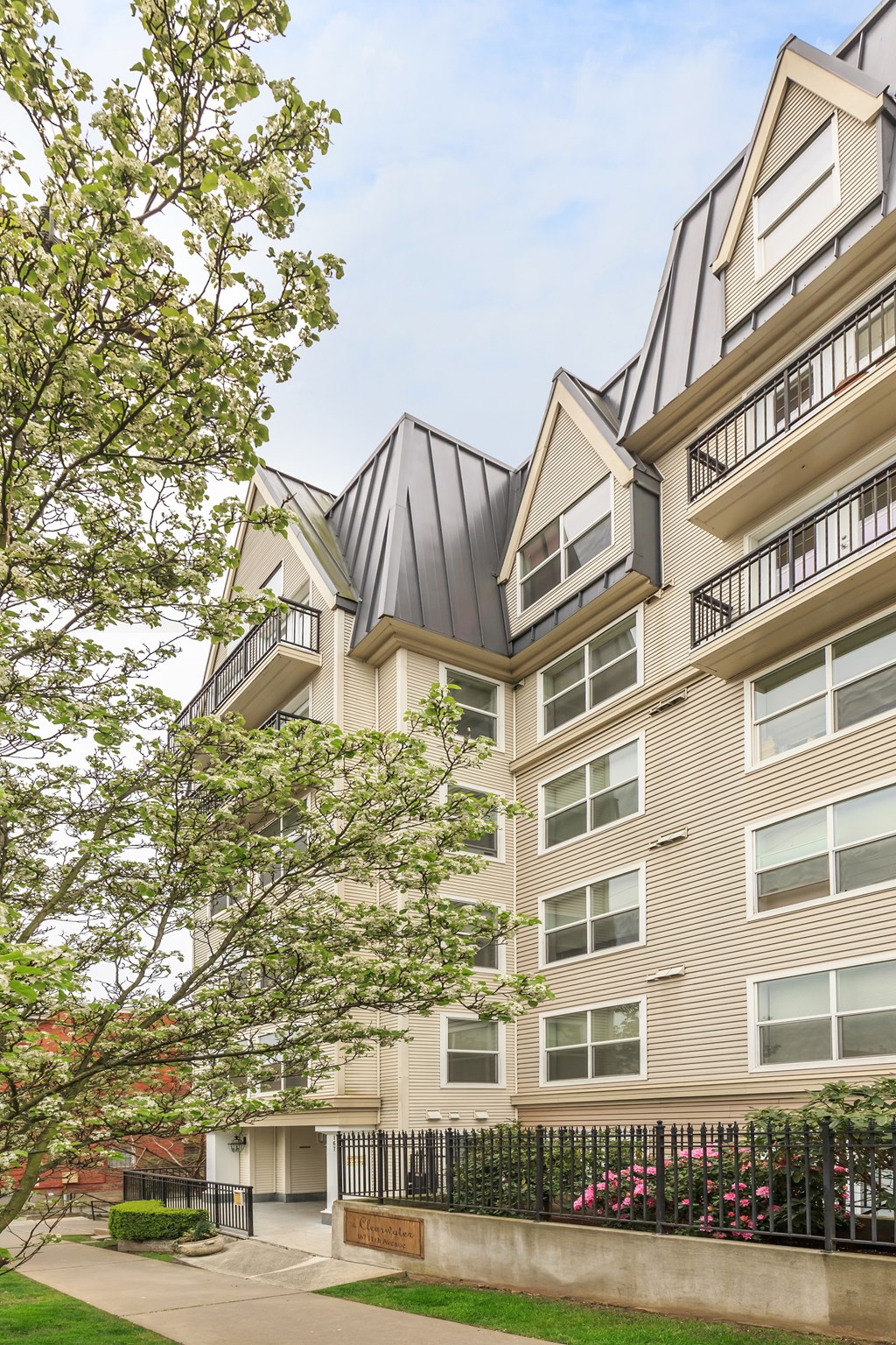 A modern building with a black metal fence in front.