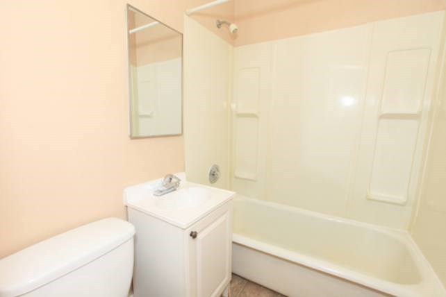 A white toilet sits next to a white sink in a bathroom.