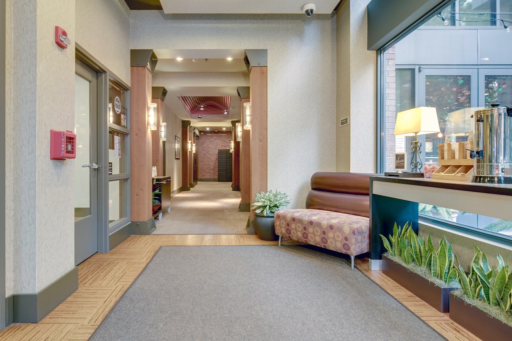A hallway with a red fire alarm on the wall.