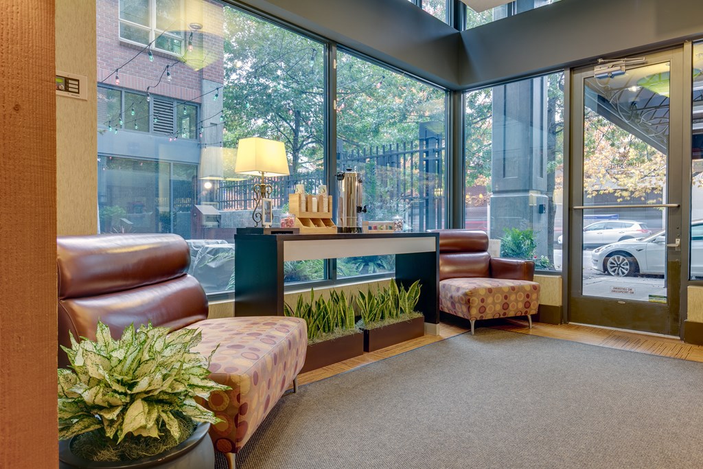 A waiting area with a couch, chair, and potted plant.