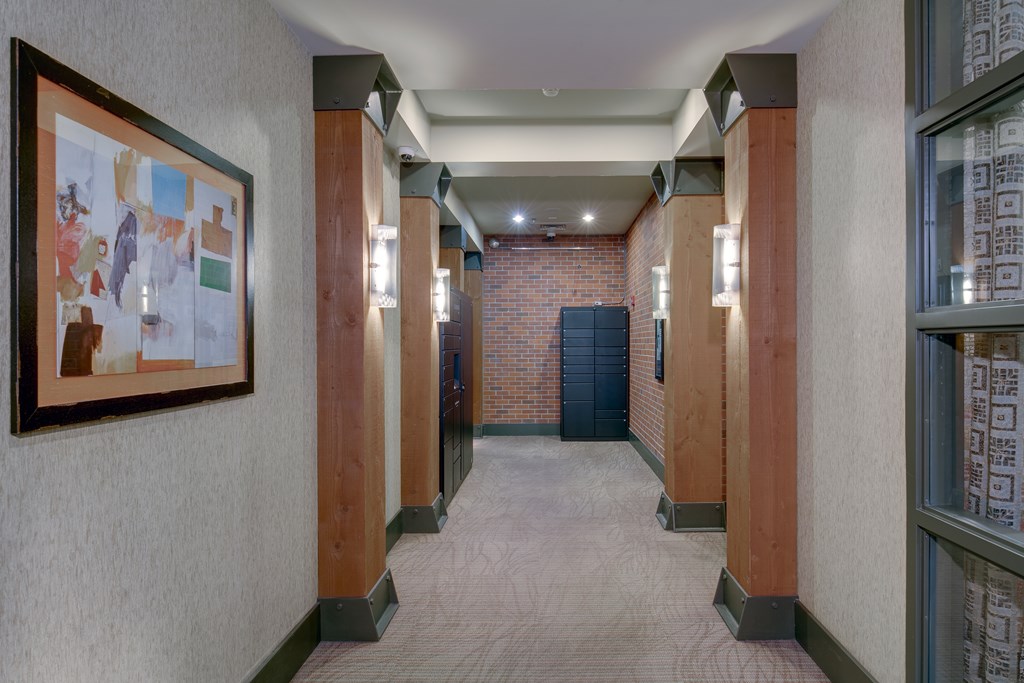 A hallway with a brick wall and a framed picture on the wall.