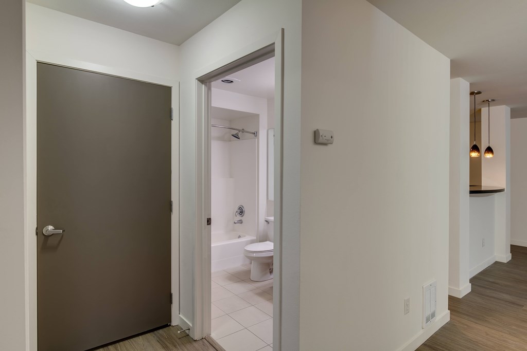 A bathroom with a toilet and sink is visible through an open door.