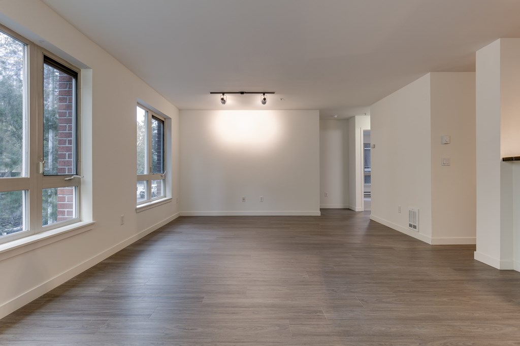 A large empty room with wooden floors and white walls.