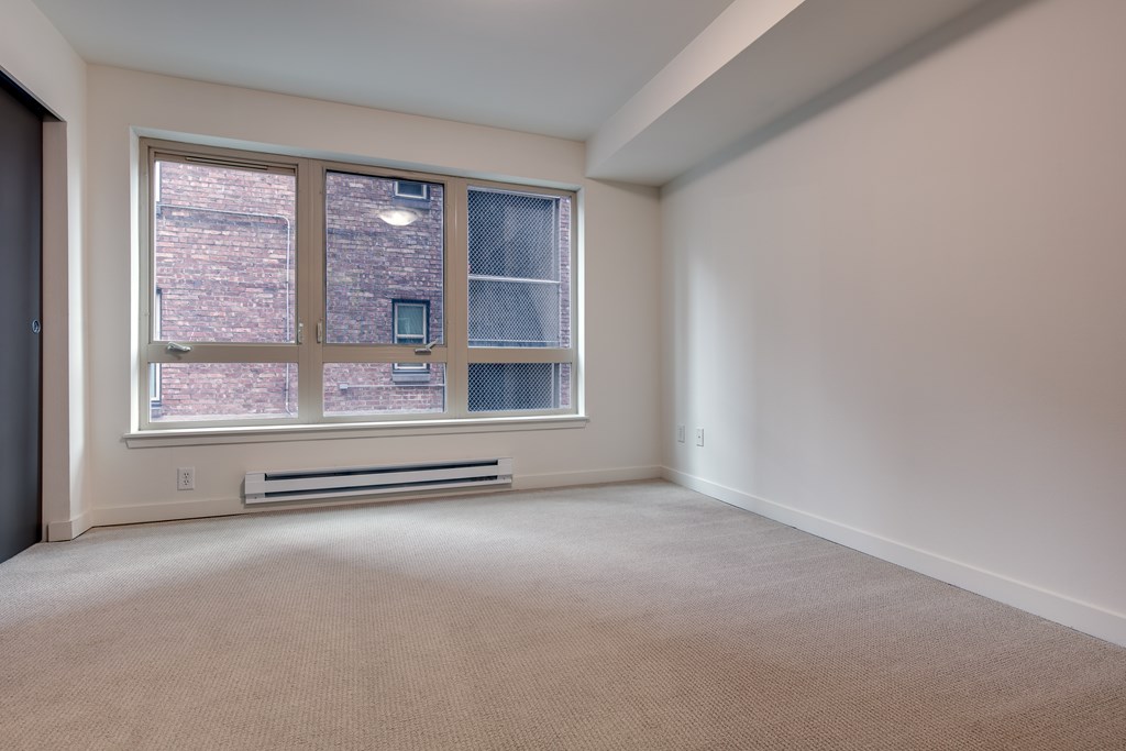 A room with a window and a radiator on the wall.