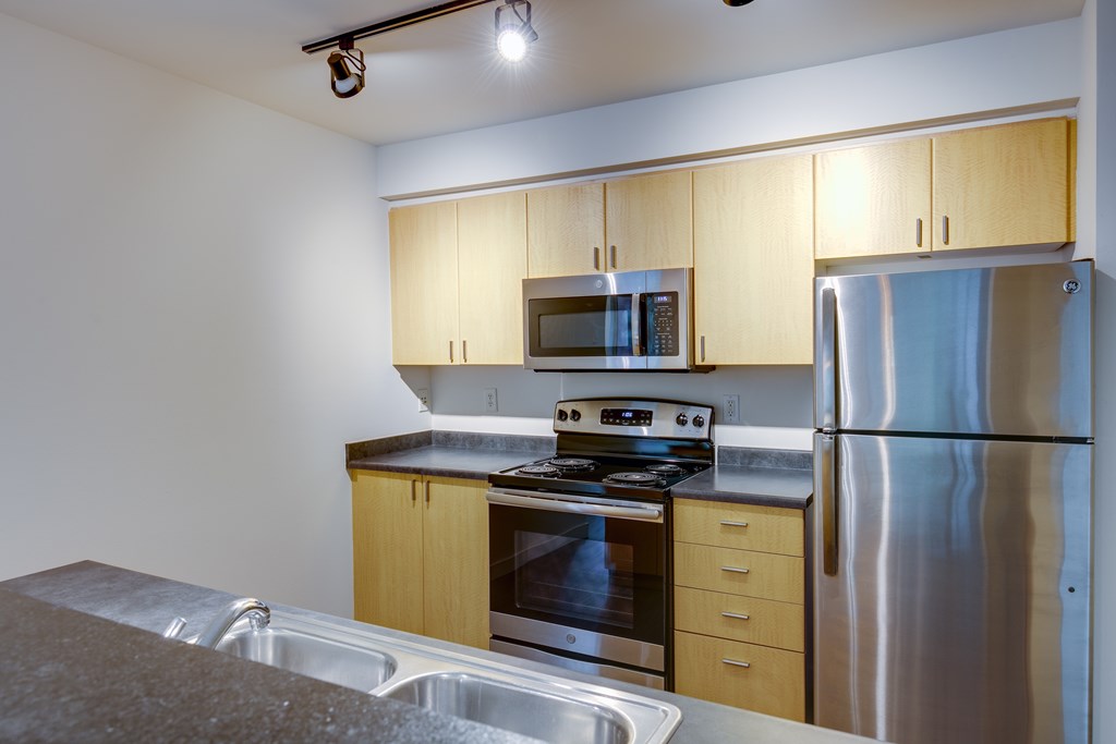 A kitchen with a stove top oven, microwave, and refrigerator.
