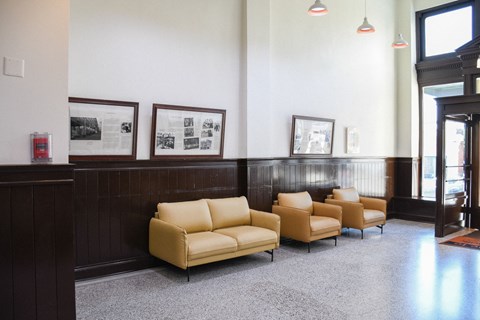 A waiting room with a row of chairs and pictures on the wall.