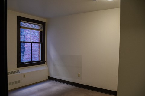 A room with a window and a radiator on the floor.