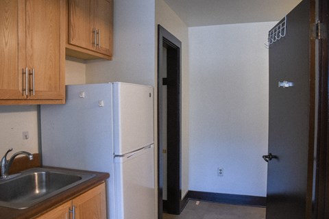 A kitchen with a sink and a refrigerator.