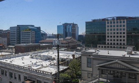 A cityscape with a mix of modern and older buildings under a clear sky.