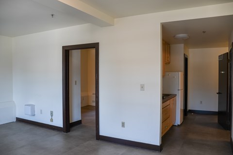 A kitchen area with a refrigerator, sink, and cabinets.
