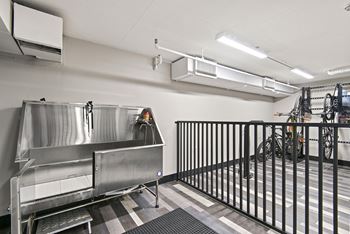 A large stainless steel sink in a room with a black fence.