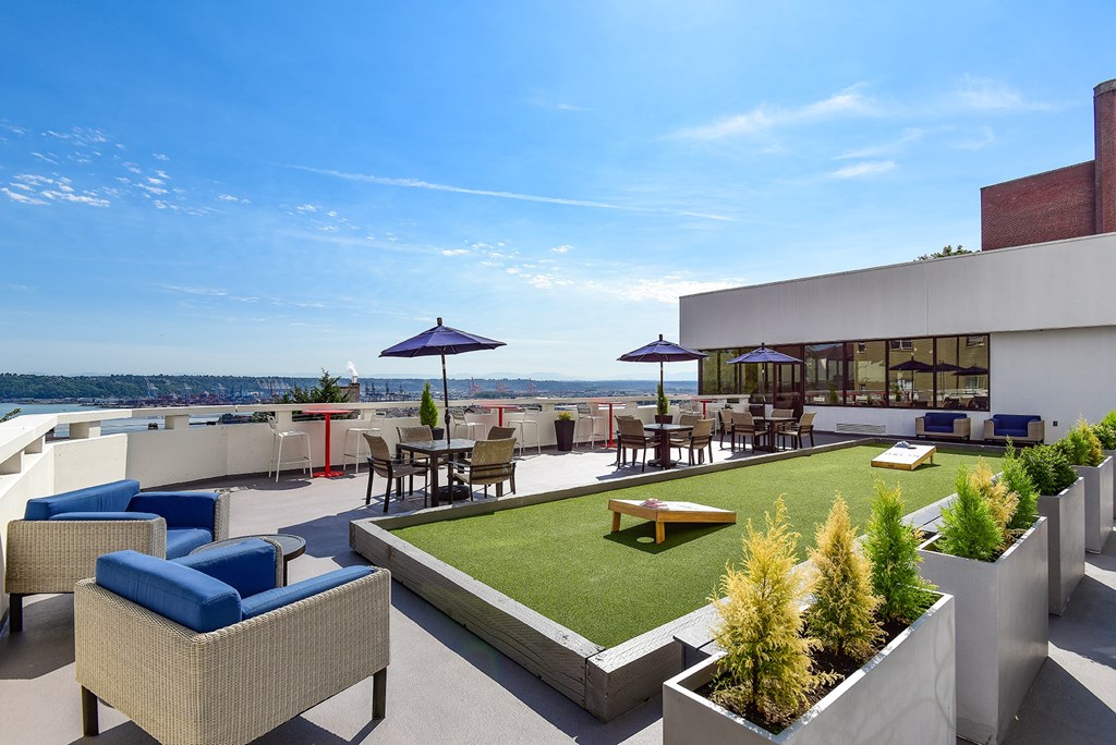 A rooftop patio with a table and chairs overlooking the water.