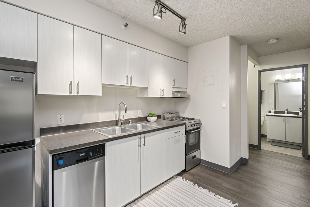Kitchen with updated appliances A modern kitchen with white cabinets and stainless steel appliances.